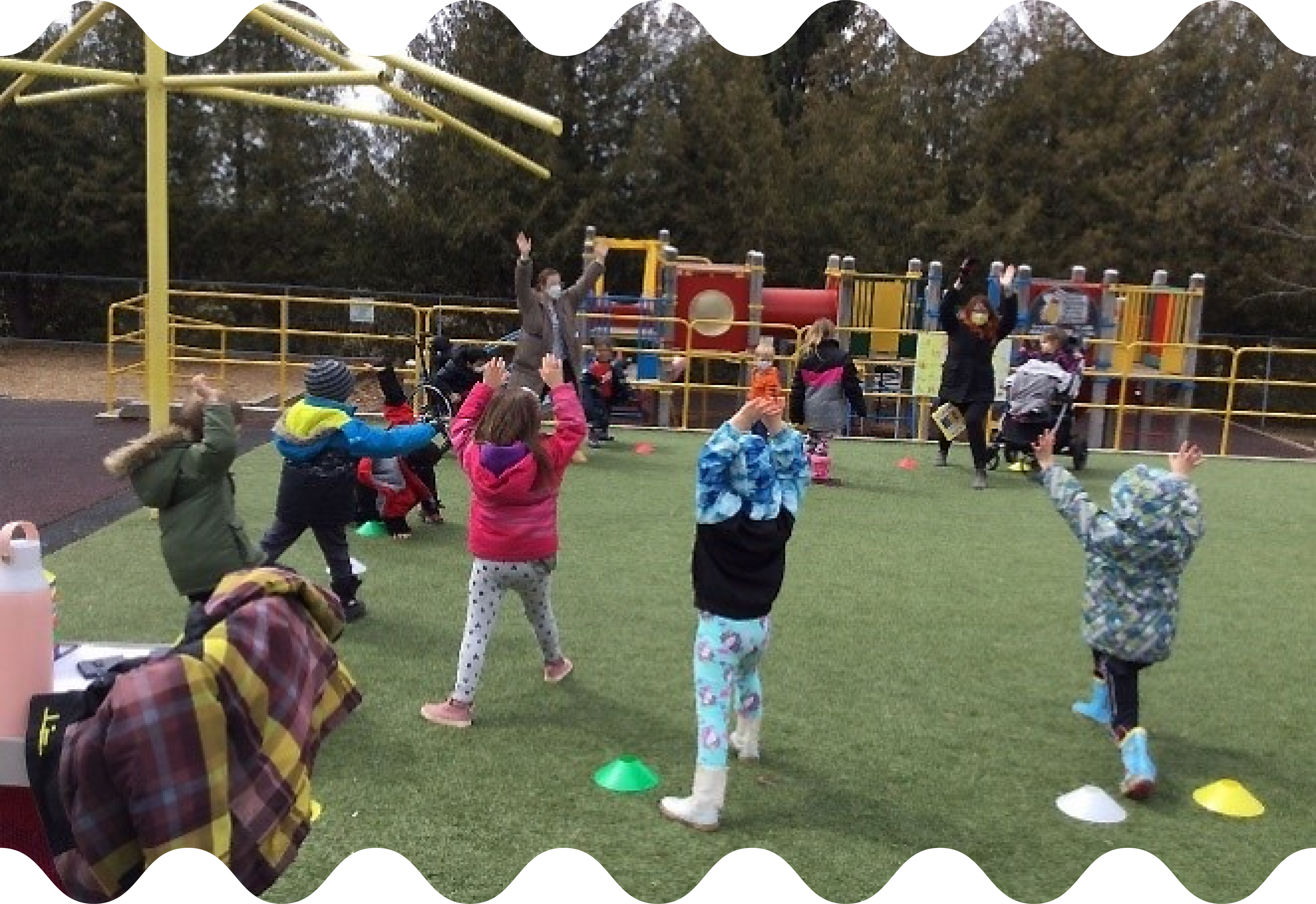 Students lunge with their hands in the air, participating in fun outdoor activities.